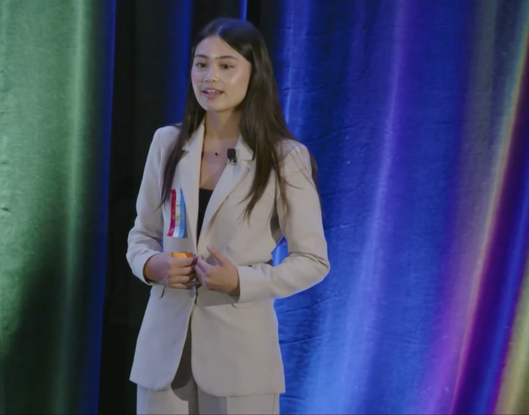 Ava DiNapoli speaking on stage at a public speaking competition
